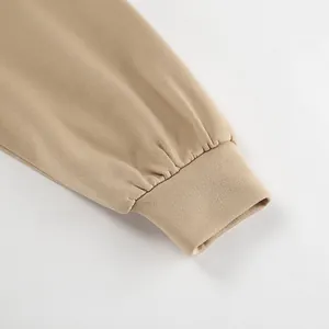 Close-up detail of a khaki oversized sweatshirt showing high-quality ribbed cuff texture