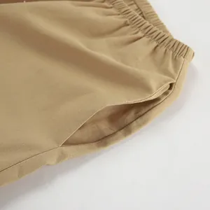 Dettaglio dei pantaloni kaki in cotone e lino con vita elastica e tasca laterale