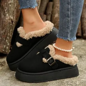 Detail shot of black platform mules with cozy beige faux fur lining and buckle strap.