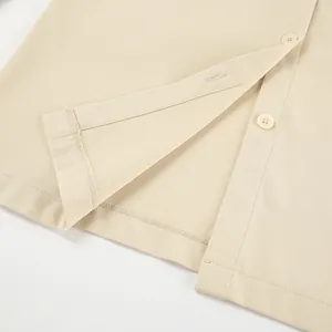 Nahaufnahme des Saums und der Knopfleiste eines khakifarbenen Workwear-Hemdkleides.