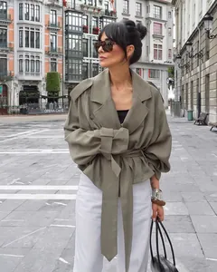 Fashionable French style khaki belted trench coat with large lapels on a city street.
