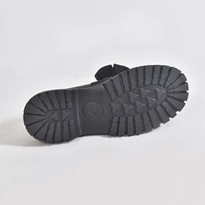 Detailed close-up showing the thick anti-slip lugged rubber sole of a black bow loafer shoe