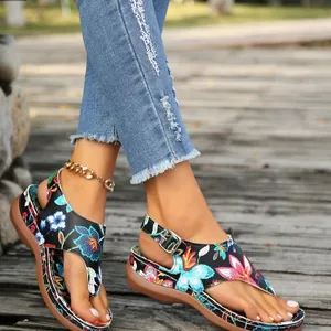 Detail showing ethnic floral embroidery on women's wedge thong sandals with buckle strap
