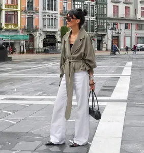 Street style view of the French lapel belted trench coat in olive green.