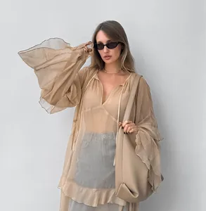 Detail view of khaki sheer chiffon dress with oversized bell sleeves and ruffle hem