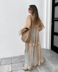 Detailed view of long sheer khaki chiffon dress with ruffles and batwing sleeves
