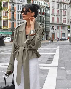 Detailed view of sage green French style cropped trench coat with tie waist and lapels