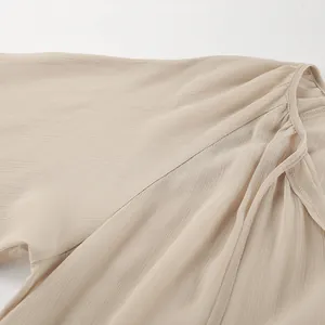 Detail shot of the khaki chiffon fabric and ruffled sleeve for a summer dress.