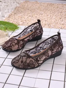 Close-up of brown floral lace mesh flats for women, breathable summer footwear style