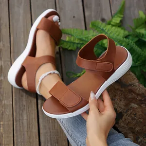 Detail view of brown Roman beach sandals with white soles and adjustable velcro straps