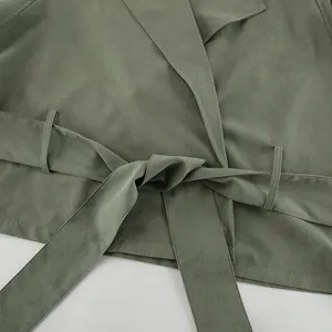 Detailed close-up view of olive green French lapel trench coat with tied waist belt