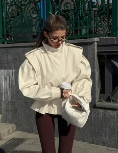 Elegante cremefarbene Schößchenjacke für Damen in einer urbanen Straßenumgebung