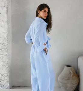 Dettaglio di un completo due pezzi in cotone e lino azzurro, camicia e pantaloni larghi