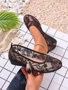 Detailed macro view showing the brown floral lace mesh texture of these stylish flat shoes.