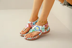 Detailed view of women's floral thong sandals with wedge heel and ethnic print