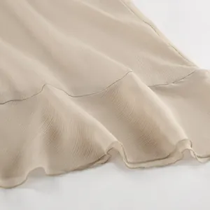 Close-up view showing the textured khaki pleated chiffon fabric and elegant ruffled hem