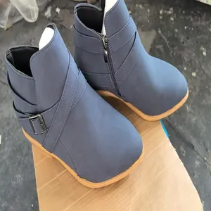 Detail view of blue Chelsea ankle boots with cross strap and side zipper decoration
