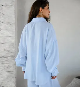 Vista posteriore dettagliata di una camicia di lino azzurra ampia con polsini a bottone