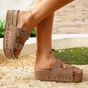 Detailed side view of brown platform suede sandals featuring decorative rivets and adjustable metal buckles