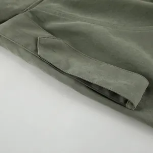 Detailed close-up of stitching on a sage green French style trench coat