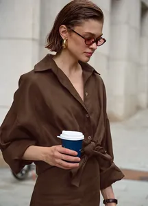 Dettaglio di un completo in cotone e lino marrone con camicia a maniche lunghe e pantaloni da donna.