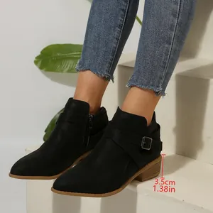 Close-up detail of black pointed-toe Chelsea boots with cross straps and 3.5cm heel.