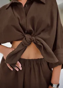 Primo piano di una camicia di lino marrone annodata in vita per un look alla moda.