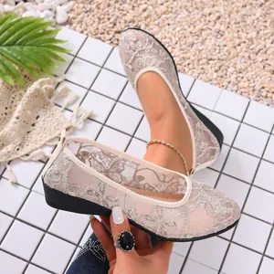 Detailed view of elegant beige mesh flats featuring floral lace embroidery and a round toe.