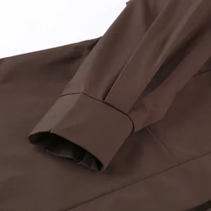 Detailansicht der braunen Trenchcoat-Manschette mit sauberen Nähten und Stofftextur.