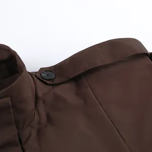 Detailaufnahme des Revers und des Schulterknopfs eines braunen Trenchcoats im französischen Stil