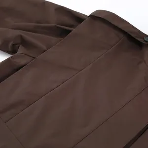 Detailansicht der Rückseite eines braunen Trenchcoats mit Fokus auf die Stofftextur