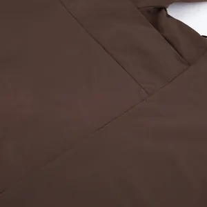 Close-up detail of high-quality brown fabric and stitching on a women's trench coat