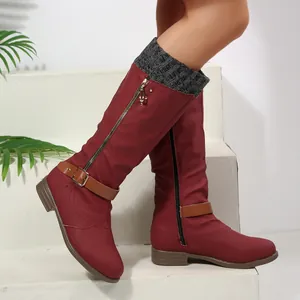 Detail view of wine red high boots with buckle strap and grey knitted collar on model.