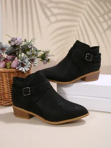 Stylish black pointed-toe Chelsea ankle boots with decorative cross straps and buckles.