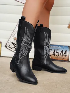 Détail de bottes de cowboy noires avec broderie blanche et design à bout pointu