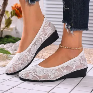 Detailed view of breathable white lace mesh flats with floral patterns and round toe.