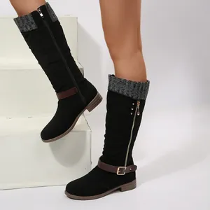 Detailed close-up of women's black tall winter boots featuring belt buckle and knit cuff.