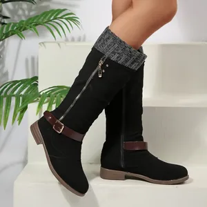 Detail view of women's black tall winter boots featuring knit cuff and metal buckle strap.