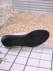Detailed view of 'LOVE' patterned anti-slip rubber outsole and mesh shoe upper