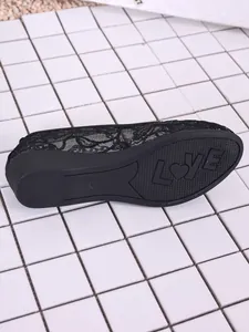 Detailed view of breathable black lace mesh flat shoe with LOVE heart pattern on the sole.