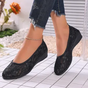 Close-up of black breathable mesh flat shoes with floral lace pattern and round toe.
