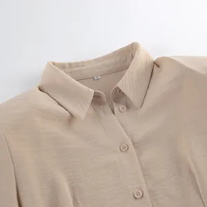 Primer plano de vestido caqui con textura rizada, detalle de cuello y botones