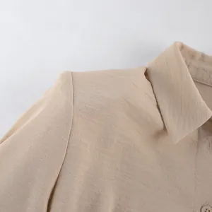Detalle macro del hombro y el cuello de un vestido caqui de tela con textura arrugada