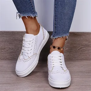 Detailansicht weißer Freizeit-Halbschuhe zum Schnüren mit dekorativen Brogue-Nähten