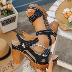 Detailed view of black platform sandals with chunky wood-like heels and white stitching