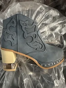 Detail view of stylish blue embroidered short boot with rivets and crystal block heel
