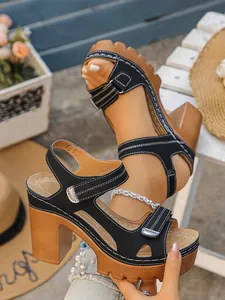 Detailed view of women's chunky platform sandals with black straps and wooden heels