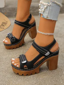 Women's black platform sandals with chunky brown high heels and contrast stitching.