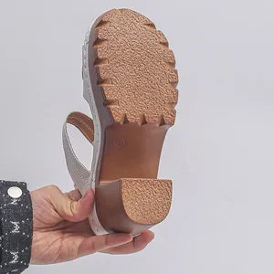 Detailed view of the textured non-slip outsole on a white platform wedge sandal