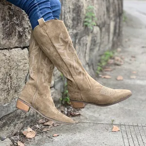 Détail des bottes de cowboy marron rétro brodées à talons épais portées en extérieur